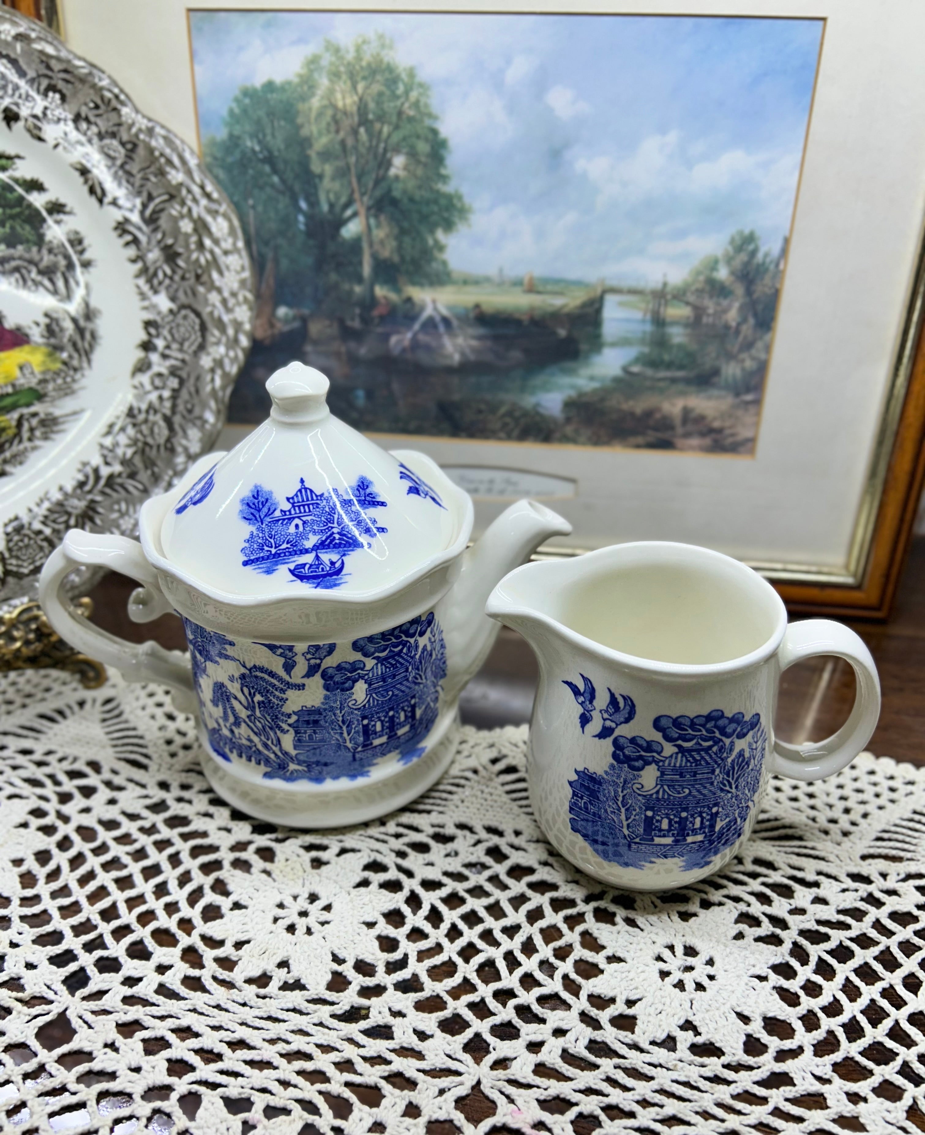Vintage Shenango China teapot and matching creamer set featuring the iconic Blue Willow pattern.
