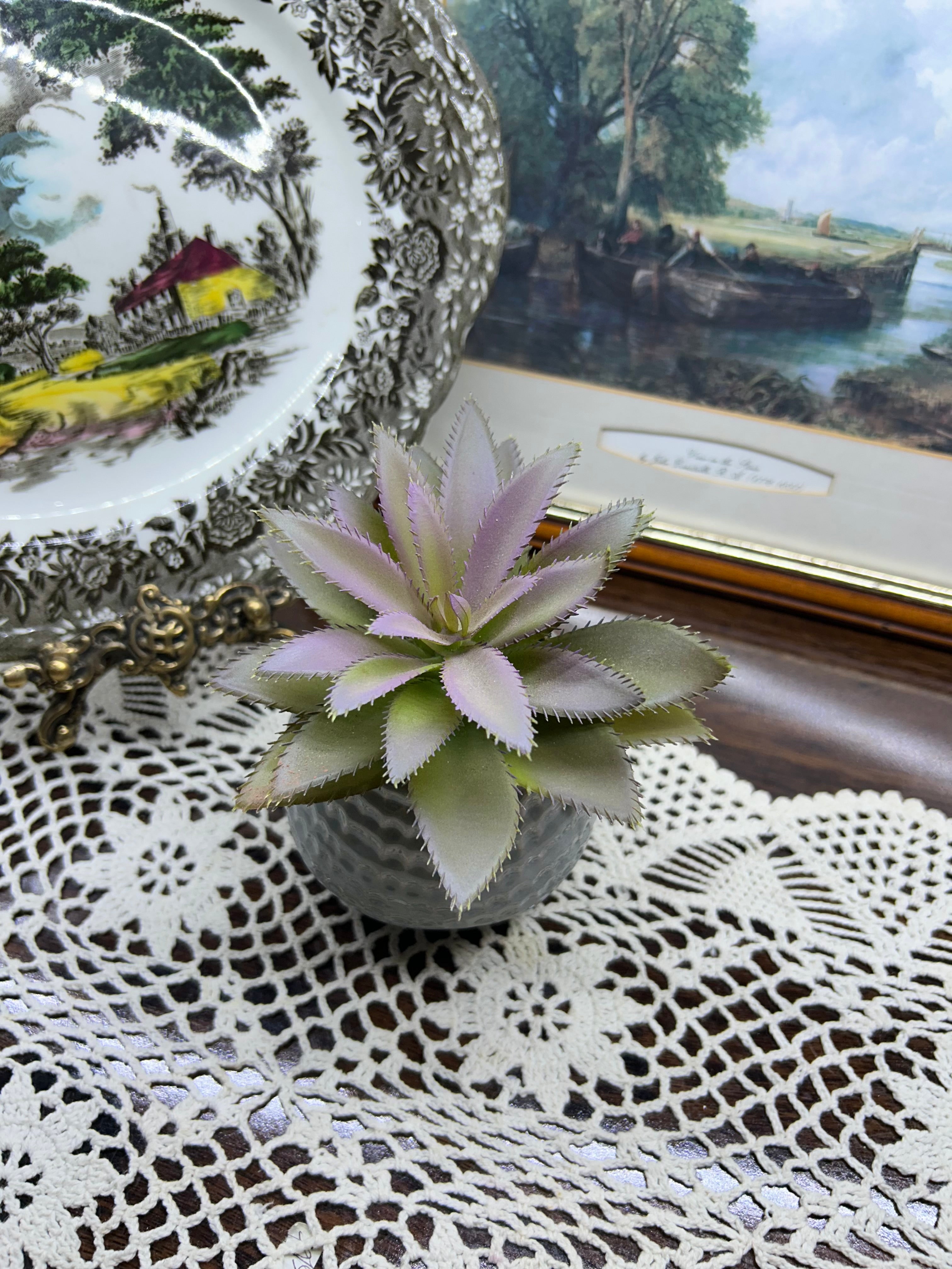 Decorative artificial succulent plant housed in a ceramic planter