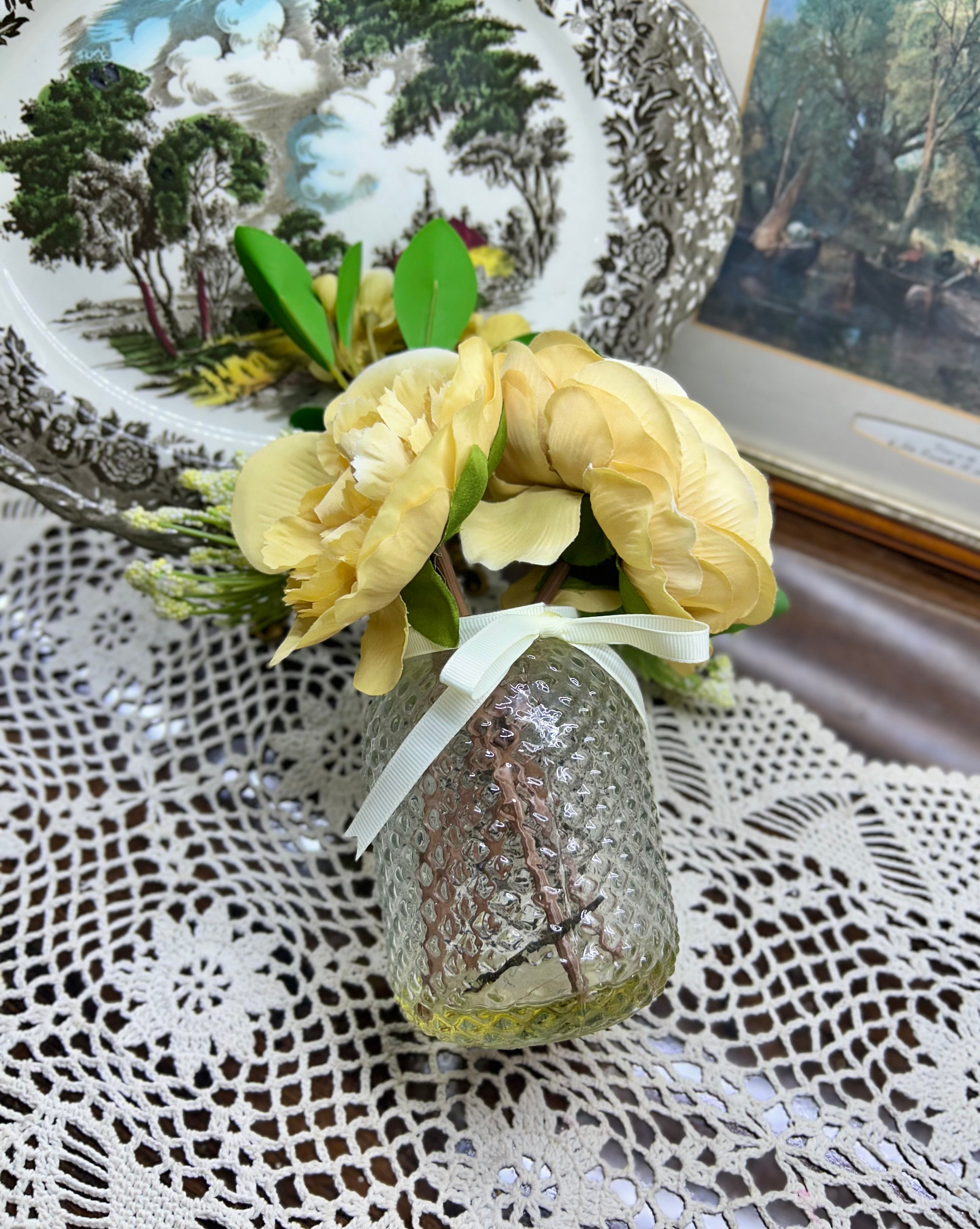 Decorative faux peony flower arrangement in a glass gel vase