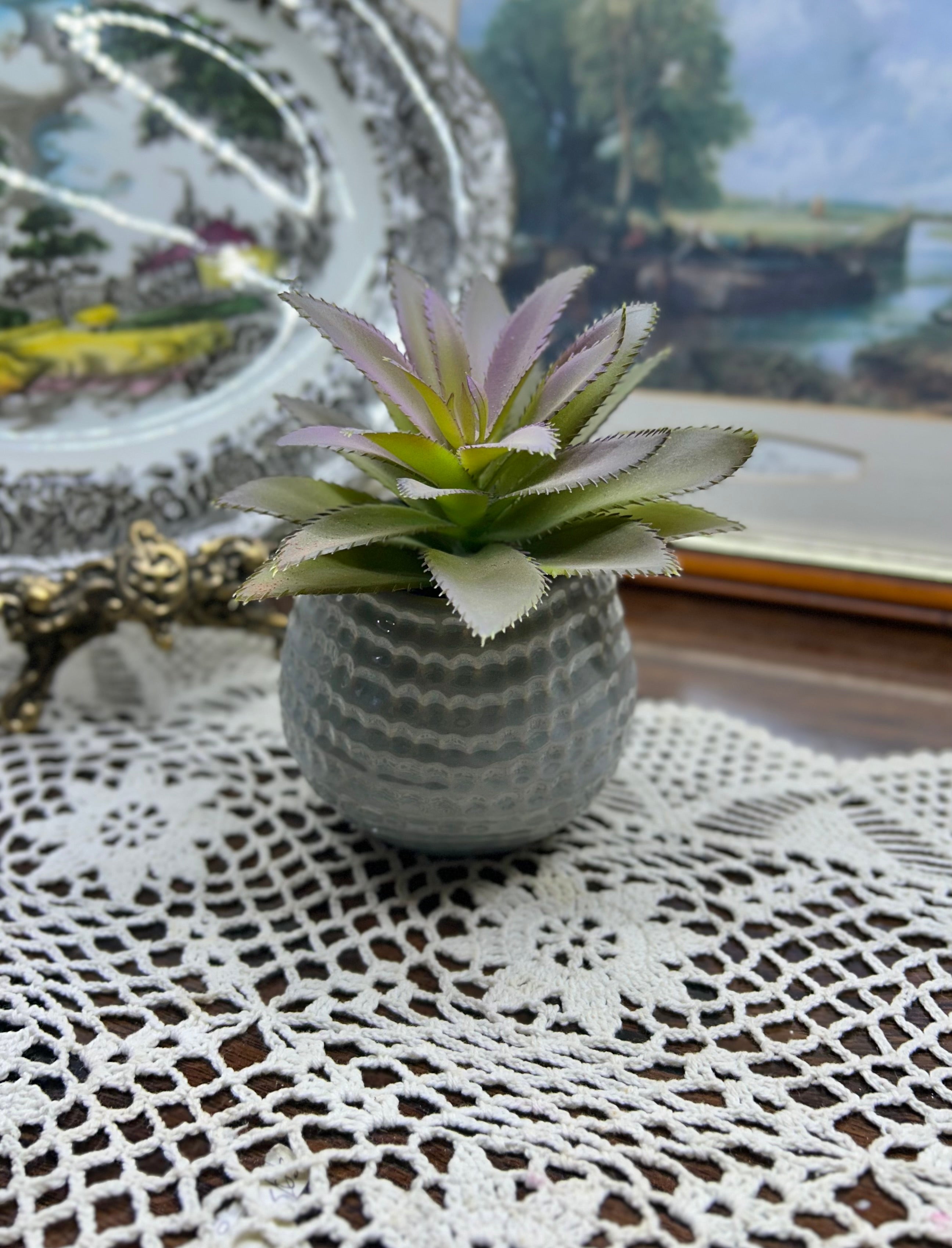 Decorative artificial succulent plant housed in a ceramic planter