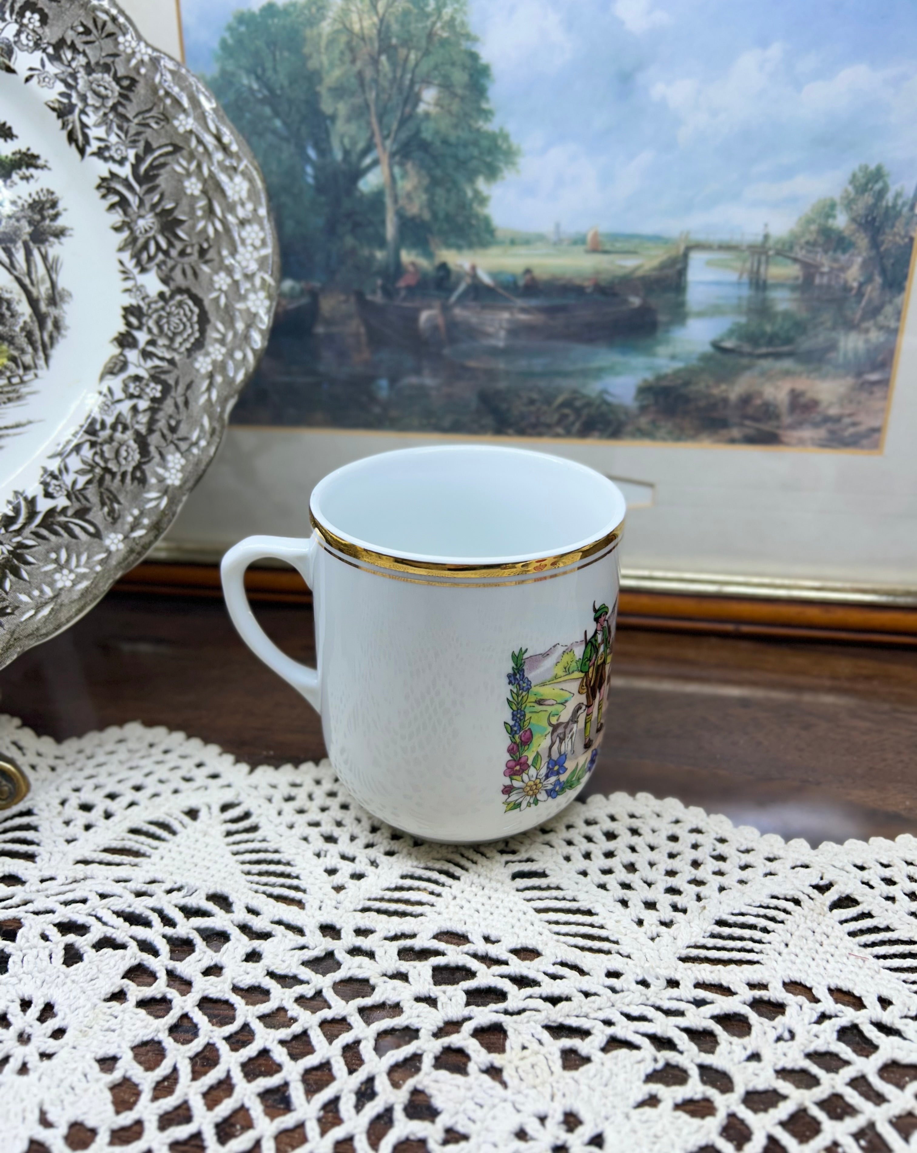 Vintage Austrian porcelain souvenir mug with a traditional folk scene — gold trim