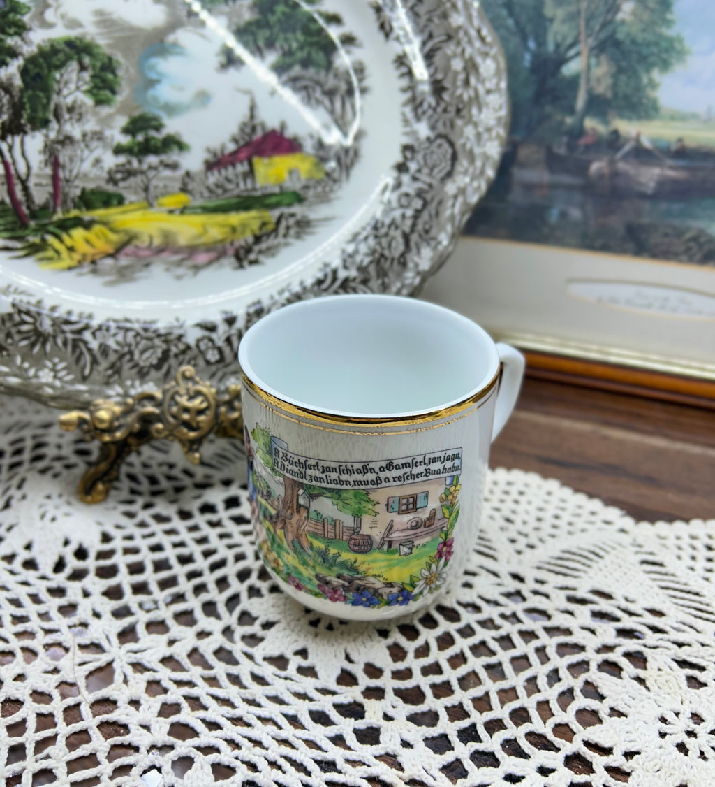 Vintage Austrian porcelain souvenir mug with a traditional folk scene — gold trim