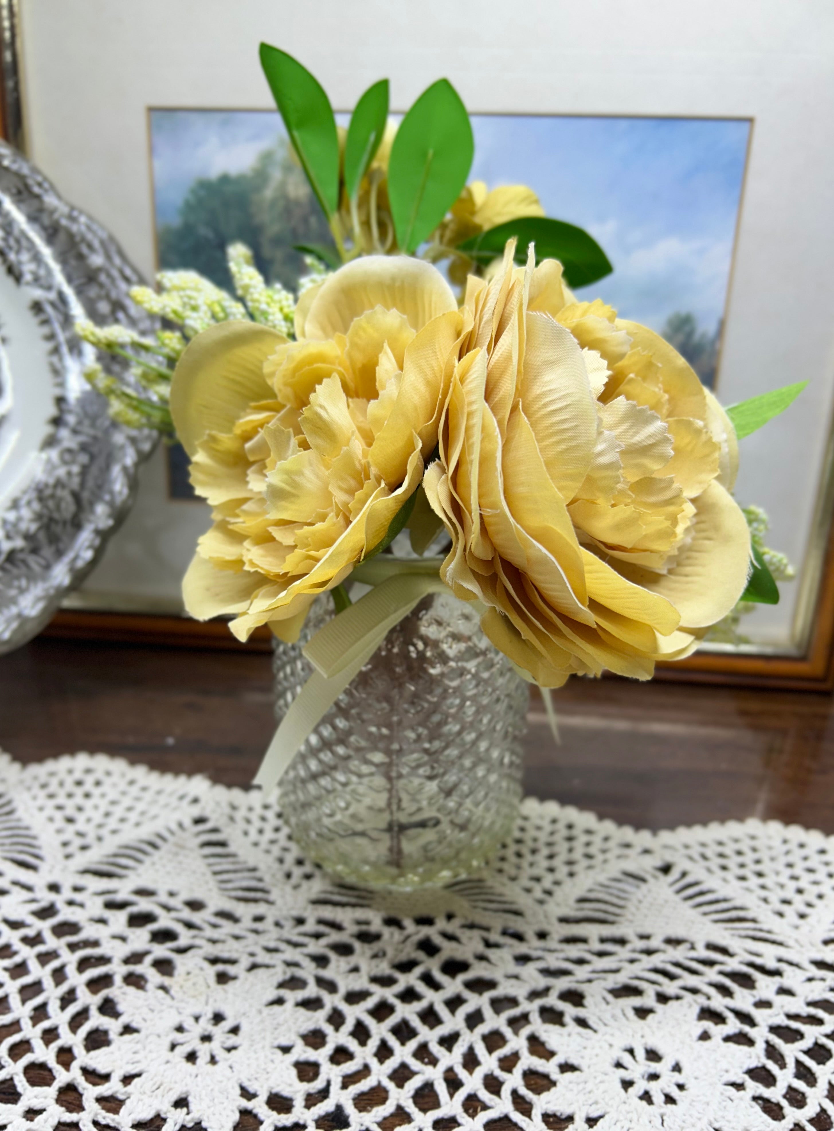 Decorative faux peony flower arrangement in a glass gel vase