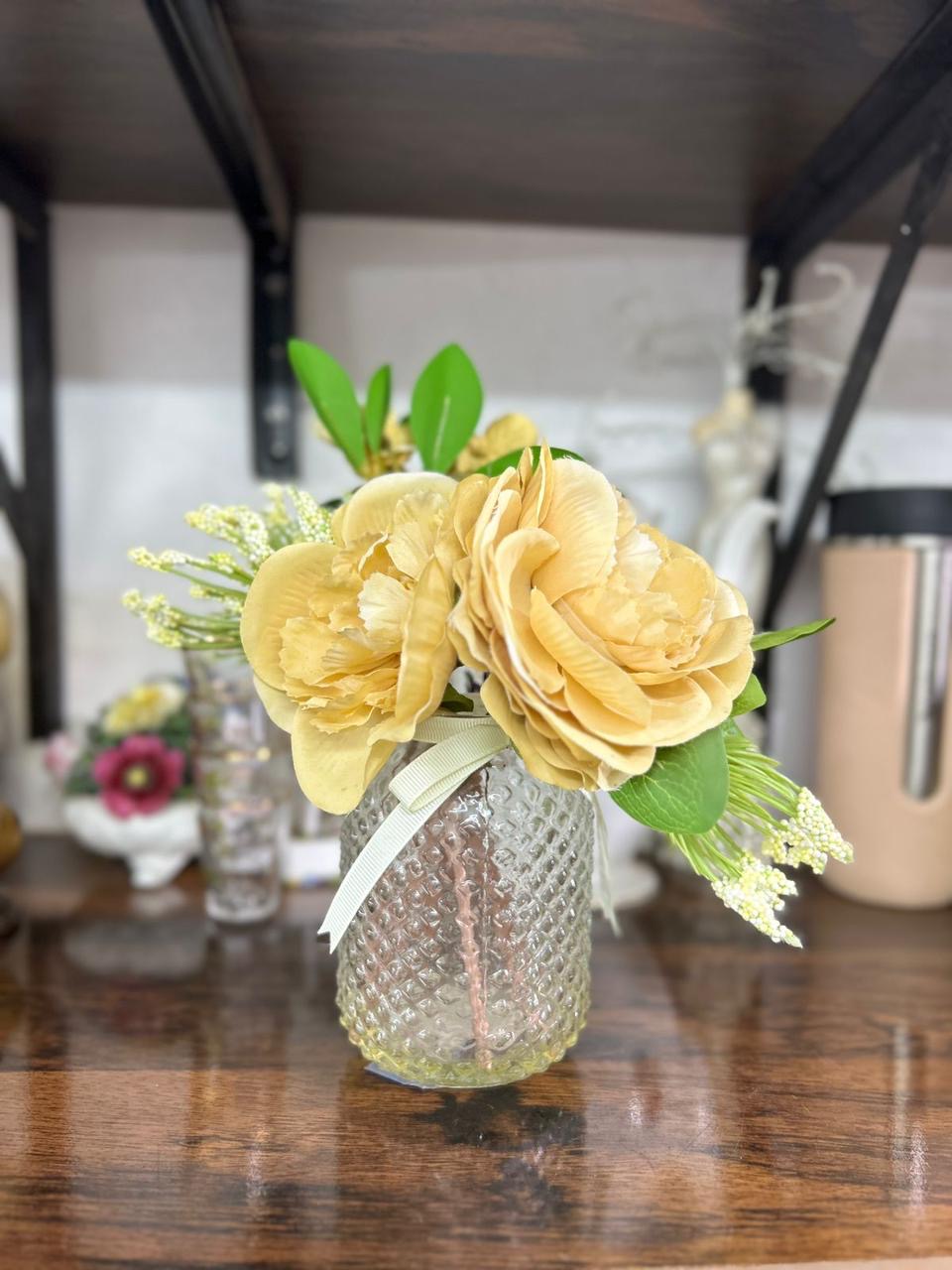 Decorative faux peony flower arrangement in a glass gel vase