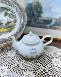 Vintage white ceramic teapot features a delicate heart garland design