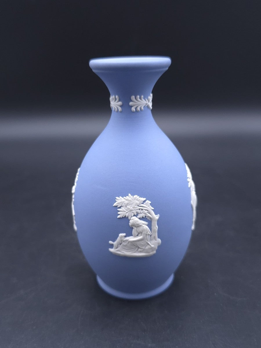 Vintage 1965 Wedgwood blue Jasperware bud vase — featuring white bas-relief cameo designs of classical figures or cherubs.