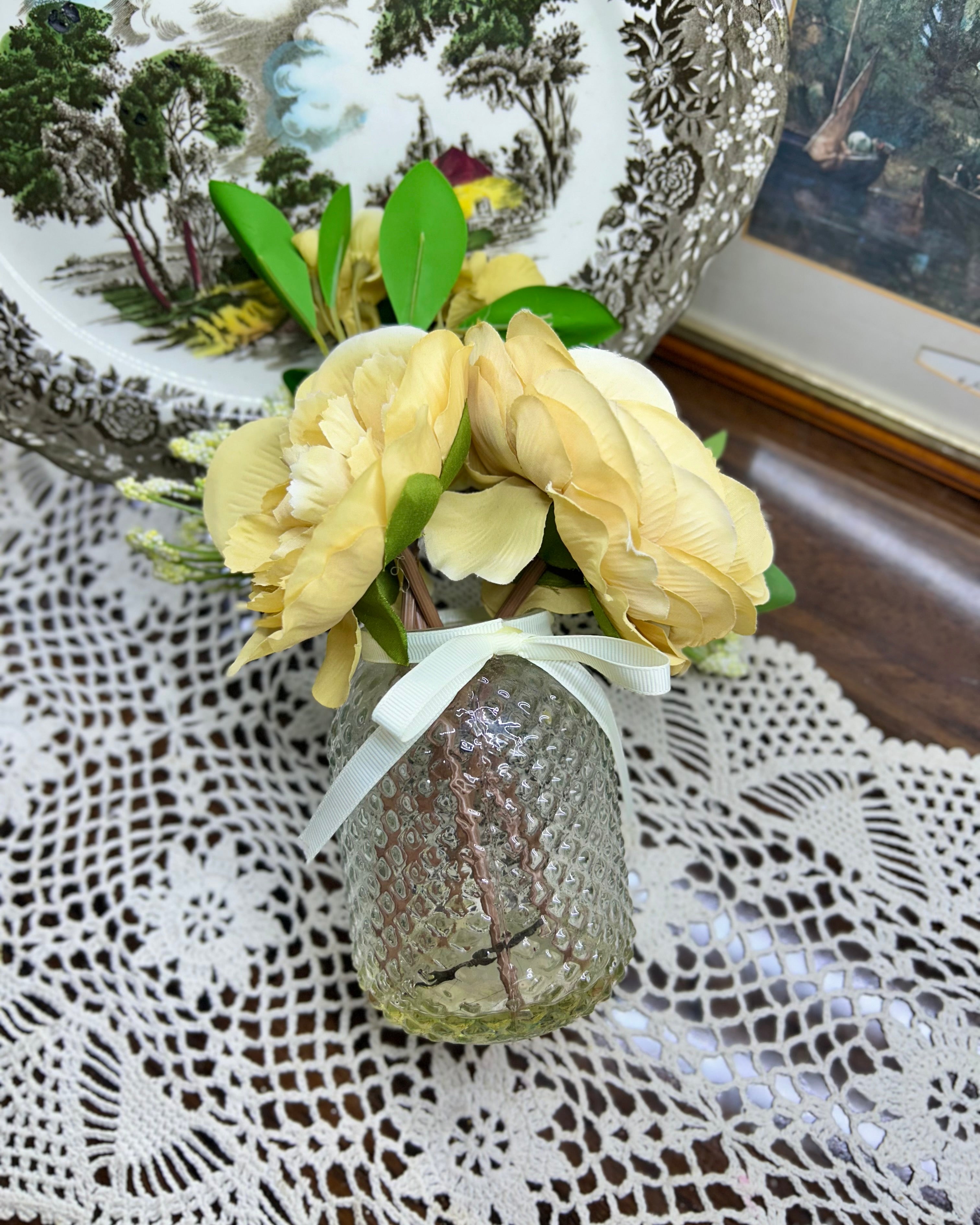 Decorative faux peony flower arrangement in a glass gel vase
