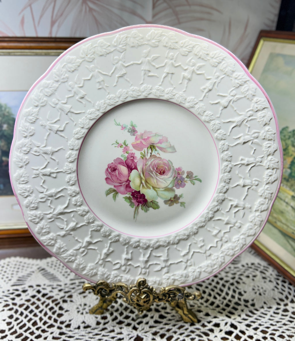 Vintage Crown Ducal Rose Marie pattern wall plate featuring a pink-tinted rim and a central rose bouquet 12”