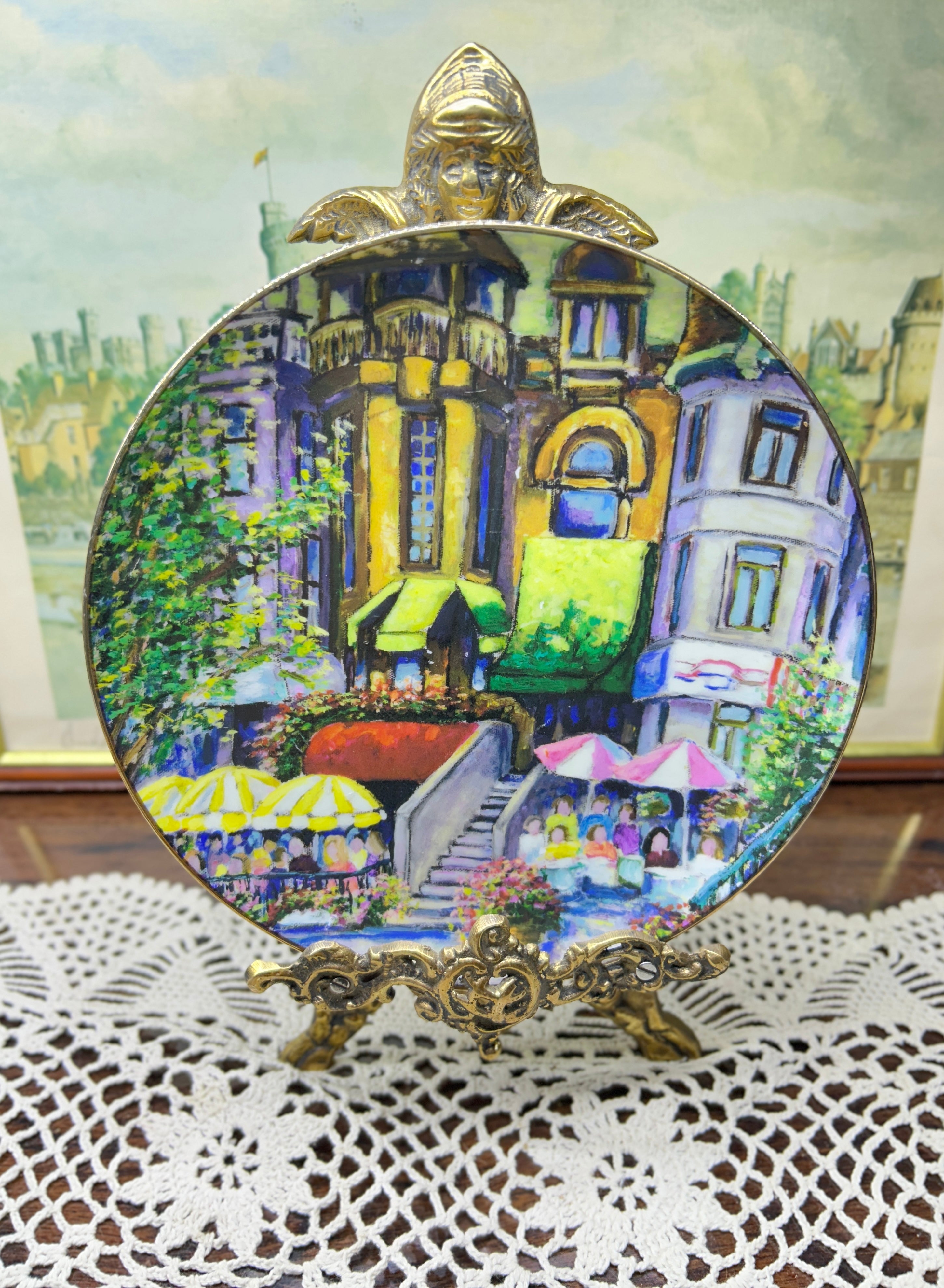 French wall decorative plate featuring a cityscape scene reminiscent of a French courtyard 7”