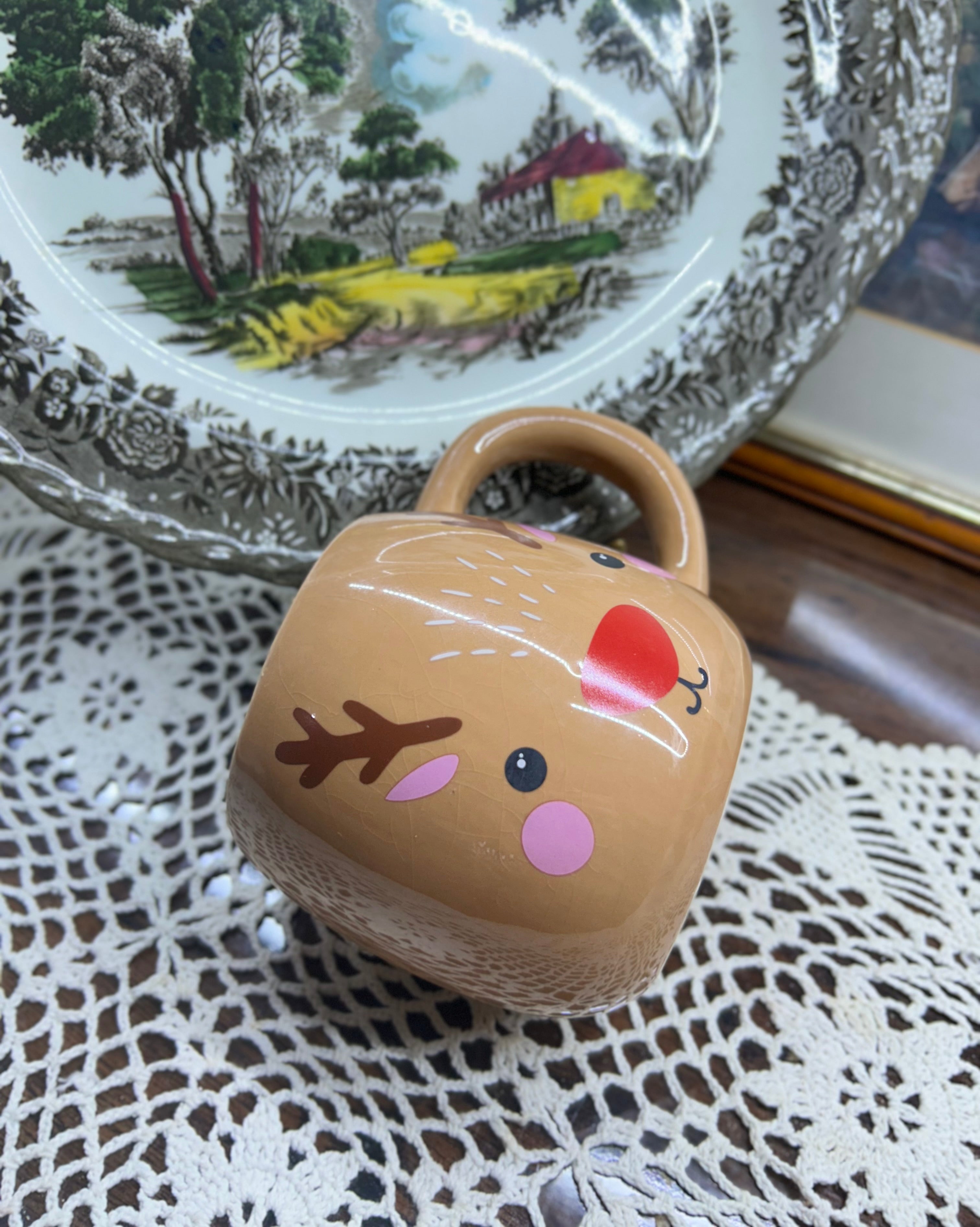 Beige reindeer mug with red nose and antler details — cermaic