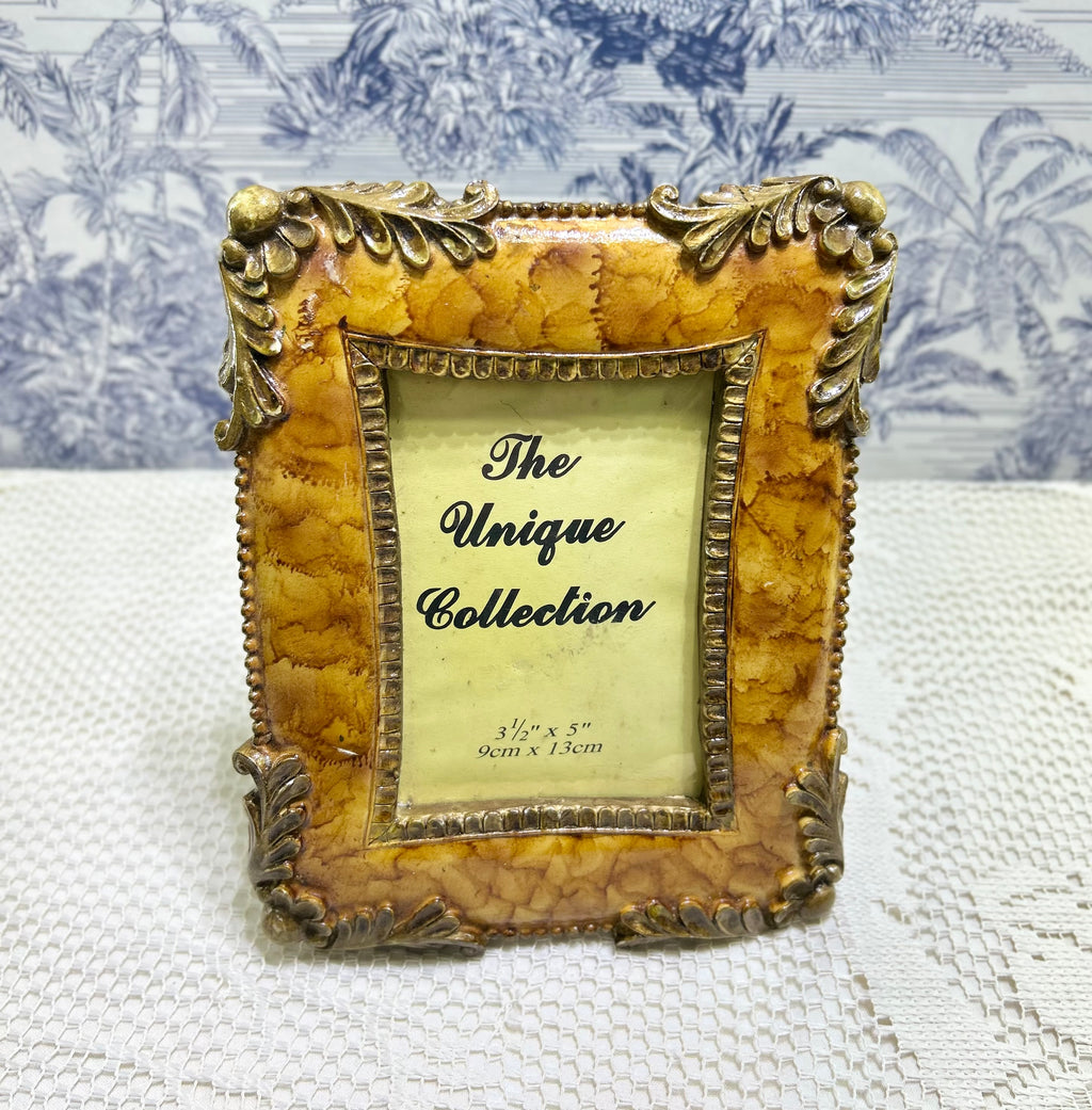 Resin photo frame with ornate antique gold border