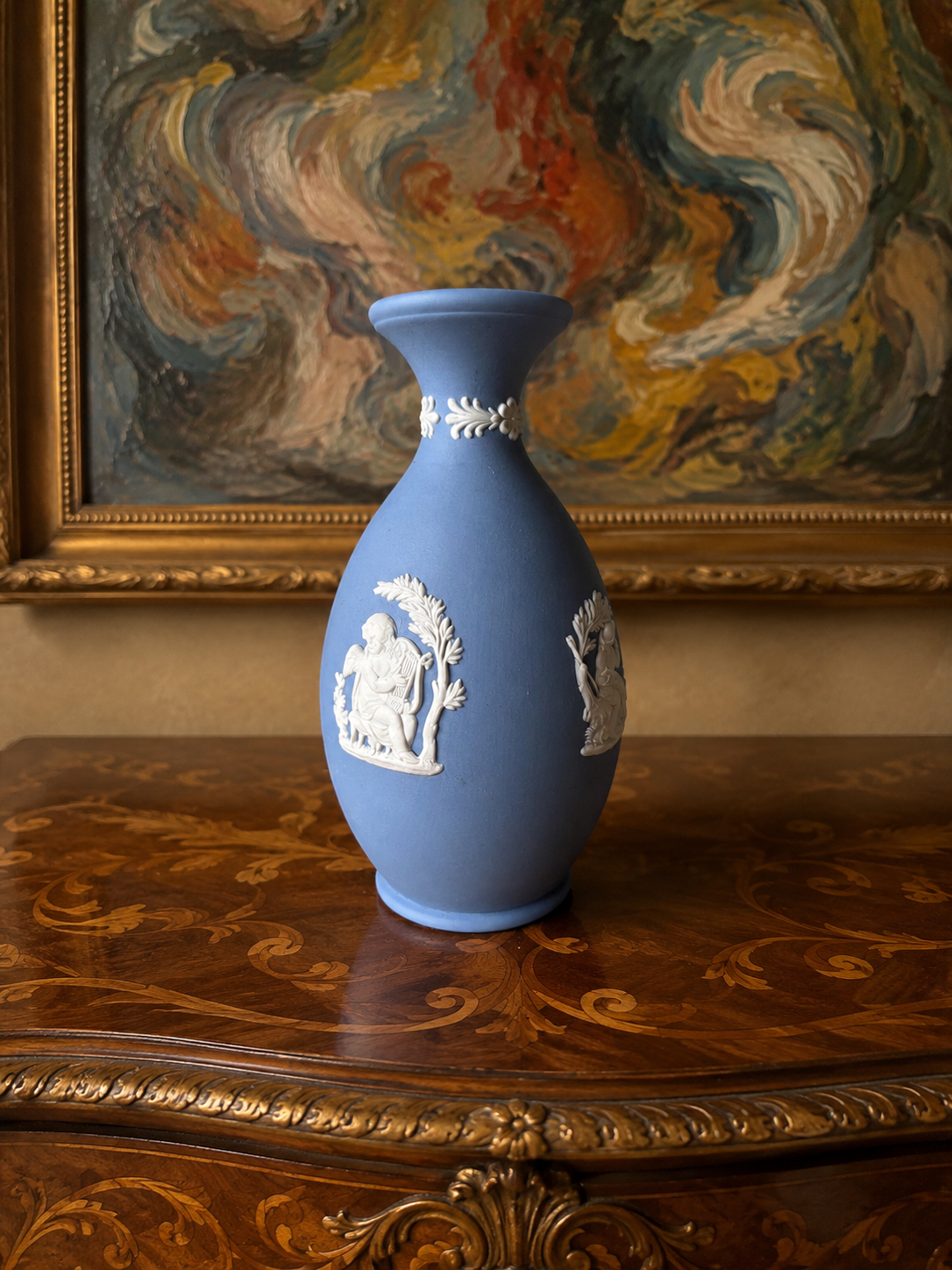 Vintage 1965 Wedgwood blue Jasperware bud vase — featuring white bas-relief cameo designs of classical figures or cherubs.