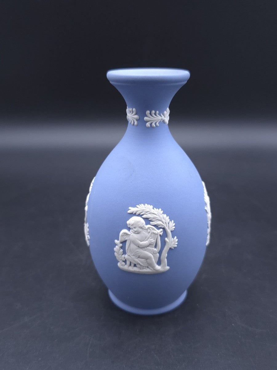 Vintage 1965 Wedgwood blue Jasperware bud vase — featuring white bas-relief cameo designs of classical figures or cherubs.