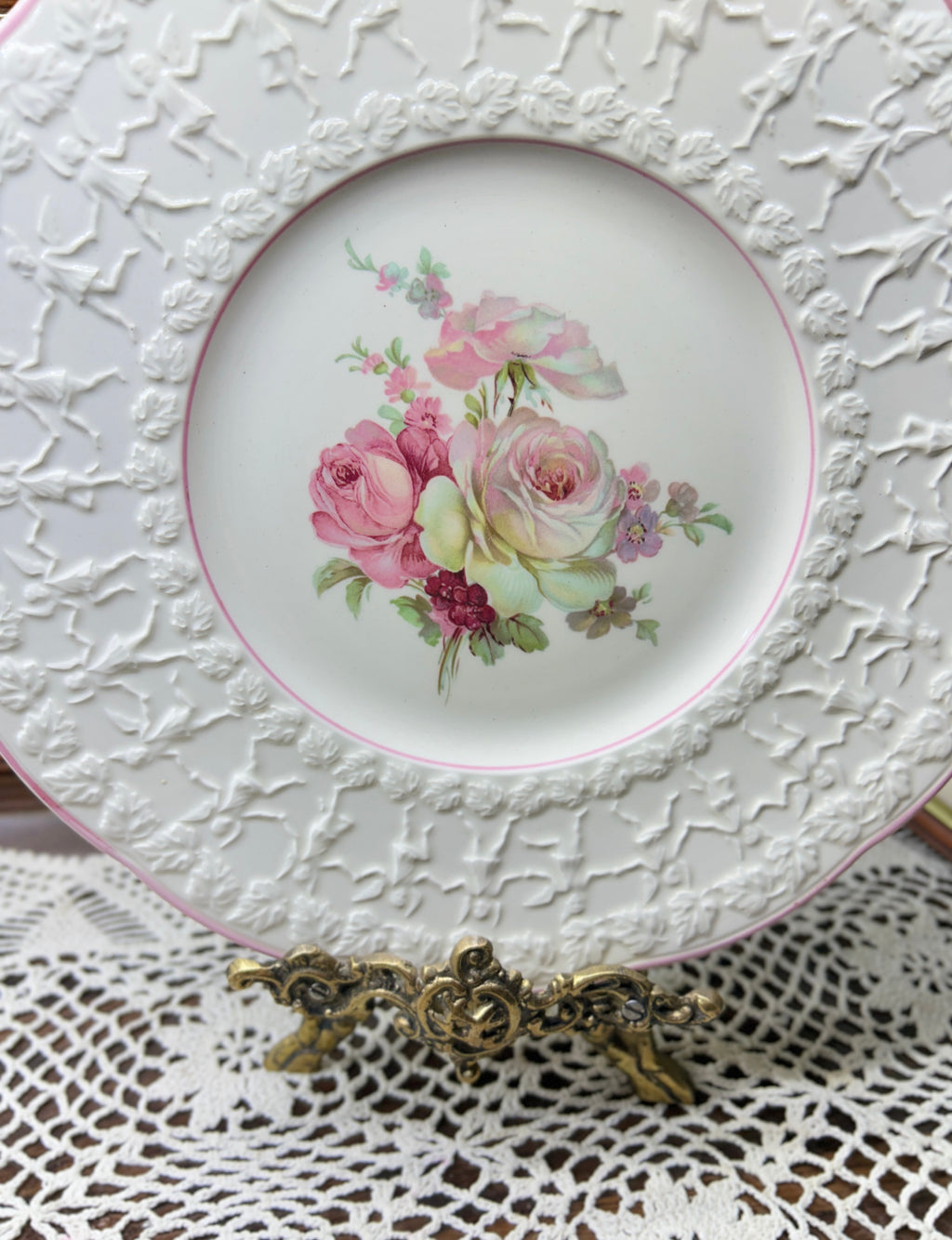 Vintage Crown Ducal Rose Marie pattern wall plate featuring a pink-tinted rim and a central rose bouquet 12”