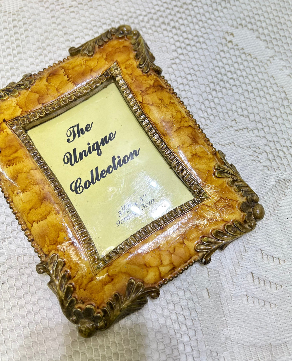 Resin photo frame with ornate antique gold border