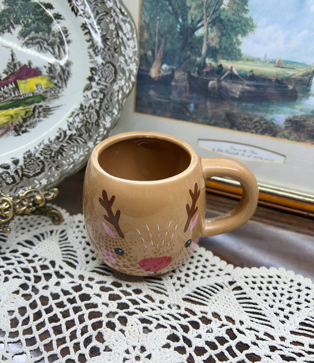 Beige reindeer mug with red nose and antler details — cermaic