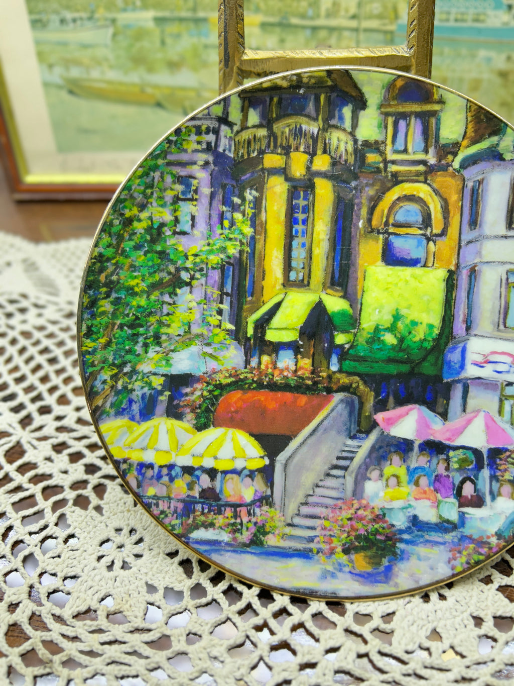French wall decorative plate featuring a cityscape scene reminiscent of a French courtyard 7”