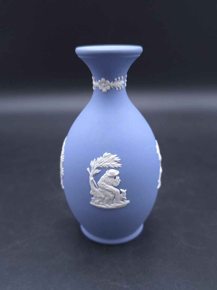 Vintage 1965 Wedgwood blue Jasperware bud vase — featuring white bas-relief cameo designs of classical figures or cherubs.
