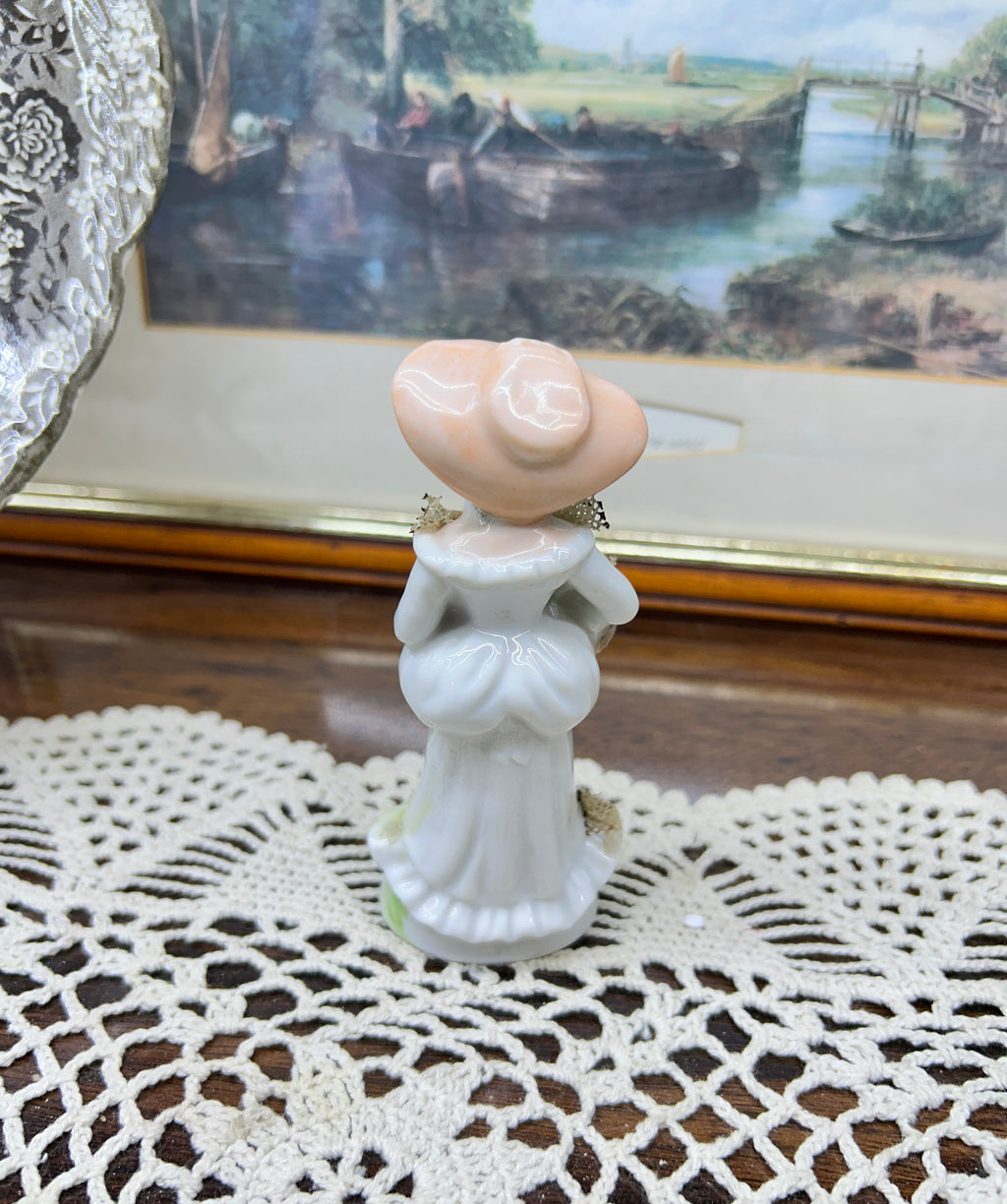 vintage Lefton figurine depicts a Victorian lady in a yellow-striped dress