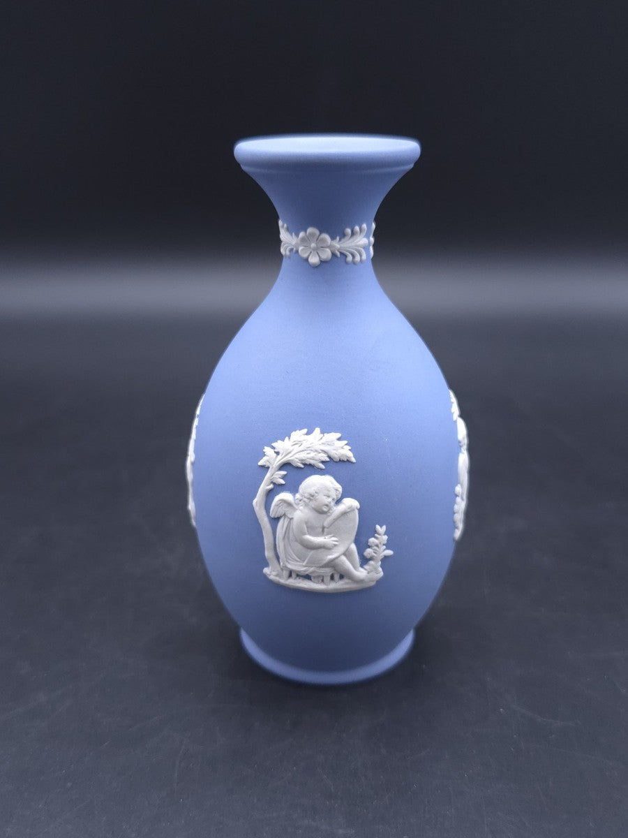 Vintage 1965 Wedgwood blue Jasperware bud vase — featuring white bas-relief cameo designs of classical figures or cherubs.